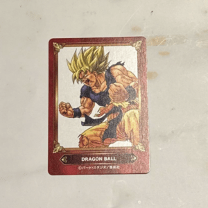 Dragon Ball trading card of Goku in Super Saiyan form, fists raised, red ornate border.