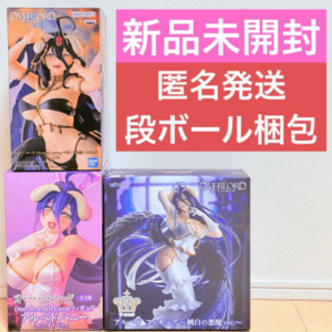 Three Overlord figure boxes on a wooden floor with a pink Japanese promotional banner on the wall behind them.