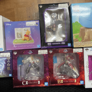 Assorted boxed collectible figurines arranged on a wooden table.