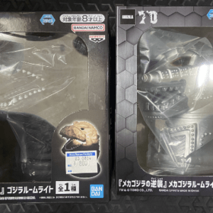 Two boxed Godzilla/Mecha-Godzilla figures in clear window packaging, black boxes with Bandai Namco logos and Japanese labels on each box, front view