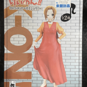 DX figure packaging showing a female character in a flowing orange dress with blonde hair on a gray brick background.