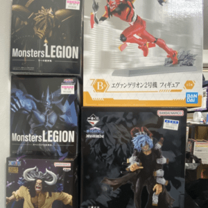 Boxed anime figures on a shelf, including two Monsters Legion boxes and a large Evangelion figure box on top right