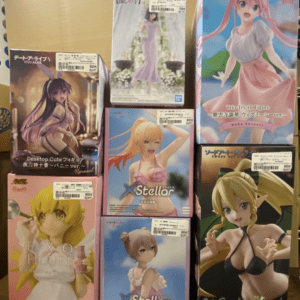 Stack of boxed anime figures on a cardboard surface, featuring colorful character boxes (Stellar, BiCute Dark, Desktop Cute, etc.).