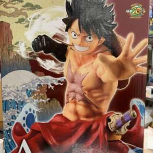 One Piece action figure of Luffy: shirtless with a chest scar, reaching forward with his right fist, wearing red sash, against a wavey ocean backdrop; Bandai logo visible.