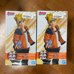 Two Naruto action figure boxes featuring the character in an orange jacket, holding a blue Rasengan orb toward the viewer (front-facing pose). This image shows duplicate boxed figures on a wooden surface.