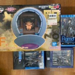 Box for Dragon Ball Z Masterlise Plus Capsule figure showing a small Goku figurine inside a blue capsule window (unopened). Fire-like background on box front with price sticker.