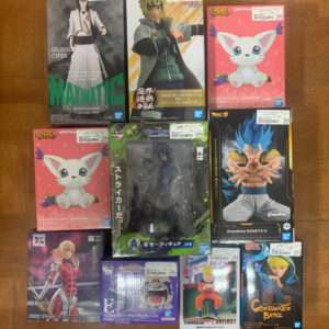 Collection of anime figure boxes arranged on a wooden floor, featuring Bleach Ulquiorra MaxMatic, Naruto figure, and pink SofVimates cat boxs