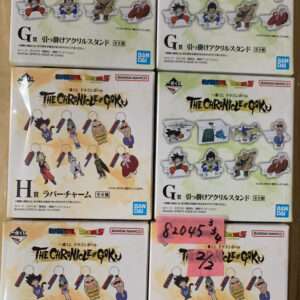 Shelf displays multiple The Chronicle of Goku rubber charm boxes featuring Dragon Ball Z characters in chibi form, Bandai branding visible.