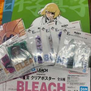 Promotional Bleach display with a large green poster of a blond anime character, surrounded by packaged Bleach merchandise and bold BLEACH text.