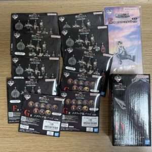 Collection of Bandai Namco blind-box figure packaging laid on a wooden surface, mostly black boxes with character silhouettes and logos.