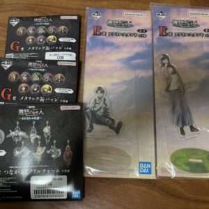 Attack on Titan prize figures and acrylic standees packaging from Bandai Namco, with multiple boxes labeled G and F prizes and two large standees in plastic cases.