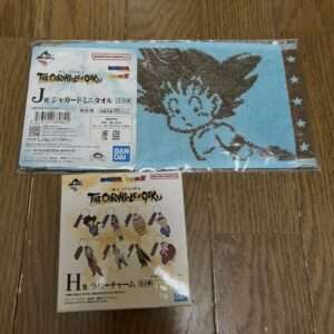 Blue towel with a black Goku silhouette from The Chronicles of Goku, in packaging with Japanese text and Bandai branding.