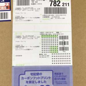 Cardboard box with a large shipping label featuring barcodes, tracking number 782 211, and sender/recipient details in Japanese, plus a blue CO2 delivery notice at the bottom.
