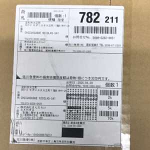 Shipping label on a brown cardboard box with Japanese text, barcodes, and numbers indicating recipient, sender, and item quantities.