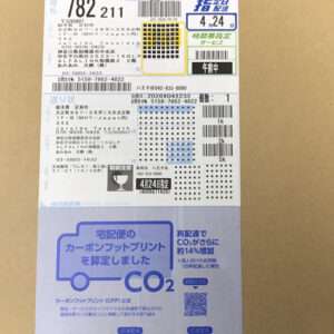 Japanese parcel delivery label with tracking and destination details, blue CO2 print section on bottom half of the card.