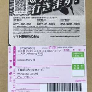 Brown cardboard box with a Japanese shipping label showing a QR code, barcodes, sender and recipient addresses, and tracking numbers.