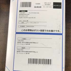 Parcel box with printed shipping labels, barcodes, and Japanese address blocks visible on the label.