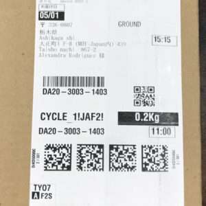Shipping label attached to a brown box with date 05/01, “GROUND” service, weight 0.2 kg, and times 15:15 and 11:00, plus multiple barcodes and QR codes for tracking and routing.