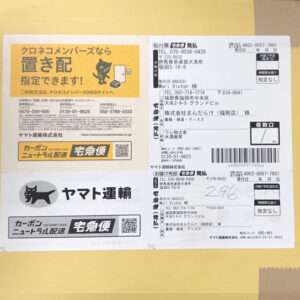 Yellow background with two Yamato Transport parcel labels featuring the black 'Kuroneko' cat logo and barcodes; a white shipping form with addresses is on the right.