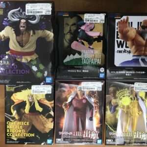 Boxed One Piece Battle Record Collection figures featuring characters in dynamic poses on glossy packaging by Bandai (left to right: large horned character, skateboard figure, muscular fists).