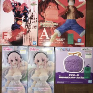 Boxed anime figures: left box features a fiery, muscular character with red flames; right box shows a Luffy figure with arms raised against a red background.