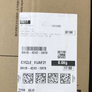 Shipping label on a cardboard box with barcodes, QR codes, and weight 0.6 kg; shows service 'GROUND' and a 07:00 time.