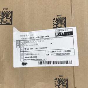 Brown cardboard box with a pasted Amazon Japan shipping label, including a barcode, recipient details in Japanese, and a date stamp (05/16–05/17).