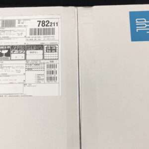 White cardboard box halves; left side has a detailed shipping label with barcodes and numbers, right side shows a blue UPS 'UP' sticker.