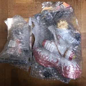 Two bubble-wrapped bundles on a wooden table containing assorted items, with price tags showing ¥3,000.
