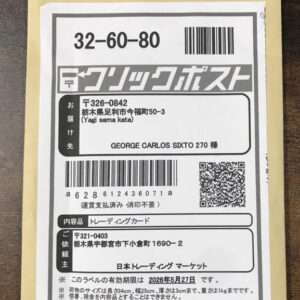 Envelope with a Japanese shipping label featuring a barcode, QR code, and recipient address in Japanese with a handwritten-like stamp area above the label.