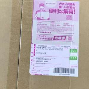 Pink delivery label on a brown cardboard box, featuring a cartoon courier and a barcode with shipment details.