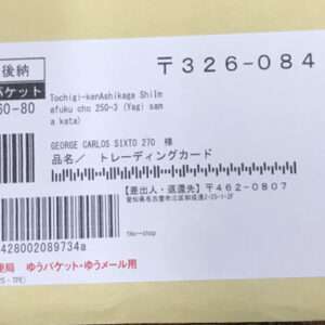 White card with multiple barcodes and Japanese text, including postal code 326-0842, a JP postal logo, and red stamps.
