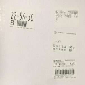 White surface with several shipping labels, barcodes, and Japanese text; a handwritten recipient line reads '437 Sofia Mancias 様' on the middle label.