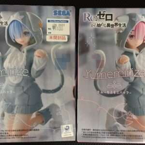 Two SEGA Re:Zero Yumemize figure boxes (Rem and Ram) in gray cat-hood outfits, displayed side by side with price stickers visible on the top-right corners of each box.