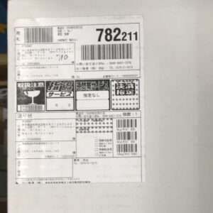 Shipping label on a white package with barcodes, a large 782211 tracking number, and Japanese delivery icons/sections