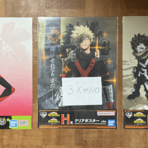 Three anime clear poster boxes on a wooden floor: left features Asuka in a red plugsuit from Evangelion; center shows Ichigo Kurosaki from Bleach with a note; right depicts Deku from My Hero Academia in a scarf against a tan backdrop.  Articulos Japan (Post Box Japan)