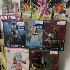 Stack of boxed anime figure collectibles on a shelf, including a Nico Robin figure and various Bandai figures with price stickers visible.