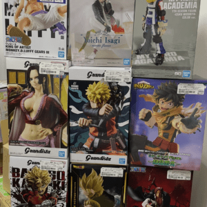 Stack of boxed anime figures on a shelf, featuring My Hero Academia, One Piece, Naruto characters.