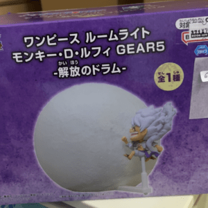 Boxed One Piece Monkey D. Luffy Gear 5 figure in purple packaging, showcasing a large gray moon prop and Luffy on a stand.