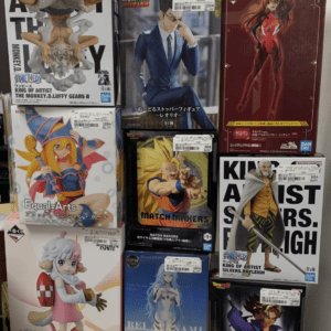Shelf of boxed anime figures on a store display, featuring One Piece, Hunter x Hunter, Evangelion, Dragon Ball, and Rayleigh boxes.