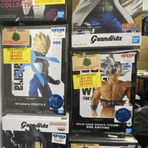 Stack of boxed Grandista anime figures on a store shelf, featuring characters from One Piece, Naruto, and Dragon Ball in display boxes.