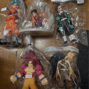 Assortment of anime action figures in clear bags on a wooden table.