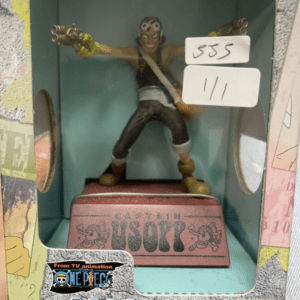 Usopp action figure from One Piece inside a display box, posed with pistols and a pink base reading Captain Usopp.