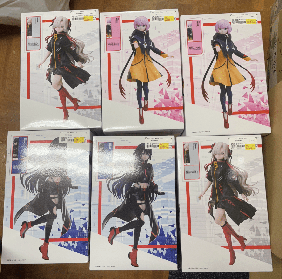 Ver Fotos Recientes 253 - Articulos Japan (post Box Japan) Boxed anime figure packages showing female characters in dynamic poses, arranged in two rows on a wooden floor. Articulos Japan (Post Box Japan)