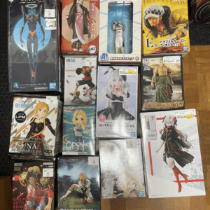 Assorted boxed anime figures laid out on the floor, including Evangelion, Demon Slayer, and One Piece boxes.