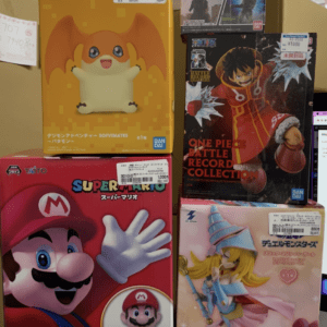 Stack of boxed collectible figures on a shelf, including Mario, One Piece, and other anime characters from various brands.