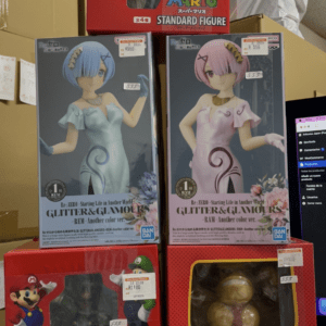 Display of boxed figures on a store shelf: red Super Mario/Mario Standard Figures and two Re:Zero GLITTER&GLAMOURS boxes (Rem in blue, Ram in pink) plus a red Mario box at the bottom.
