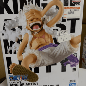 Box for One Piece figure: Monkey D. Luffy in Gear 5 pose with orange shirt and white pants, surrounded by white cloud effects; packaging reads 'KING OF ARTIST' and includes Bandai logos.