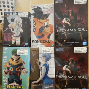 Shelf of boxed anime figures: Dragon Ball's Son Goku, My Hero Academia hero, One Piece Battle Records, and Theorama Soul collectibles.