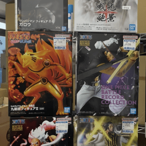 Boxed anime figures on a store shelf, featuring characters from One Punch Man, Naruto, and One Piece.